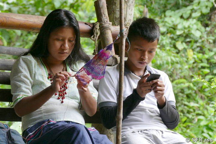 Geschwister flechten mit Smartphone, Ecuador