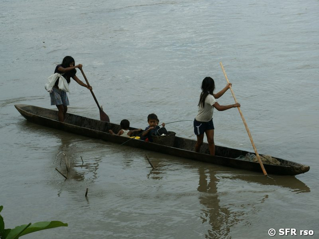 Indigene Kinder mit Holz Kanu paddeln auf dem Rio Napo in Ecuador